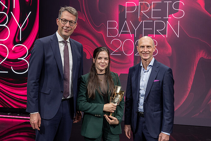 Das Bild zeigt zwei Männer und eine Frau bei der Verleihung des Bayerischen Kulturpreises.