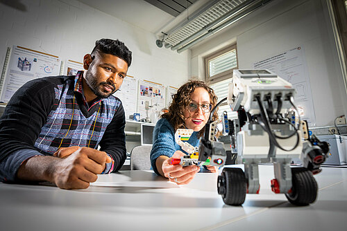 Students explore a robot in a lab in Rosenheim.